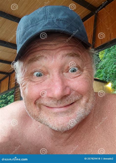 Funny Portrait of a Smiling Aged Man in a Cap with Bulging Eyes Stock