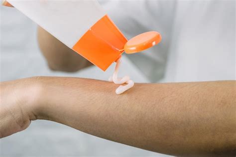 premium photo  woman applying  skin care cream arm