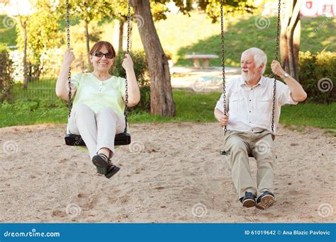 senior couple swinging   park stock photo image  happy