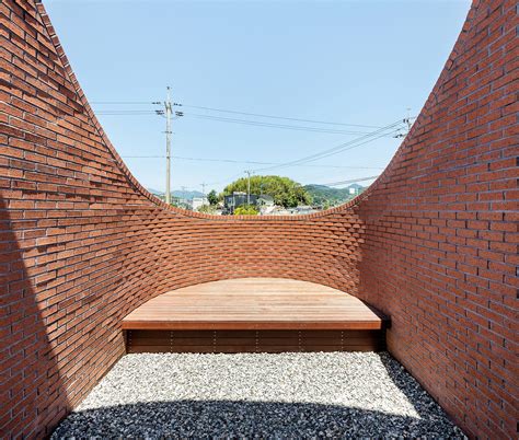 Obba s vault house features hidden gardens behind curving brick walls