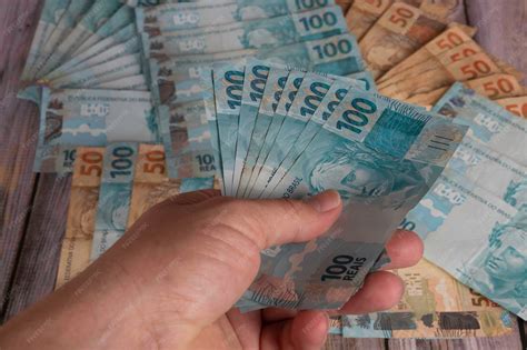 50 Mil Em Notas De 100 - Mão de um homem segurando notas de 100 reais com notas de 50 e 100 ...