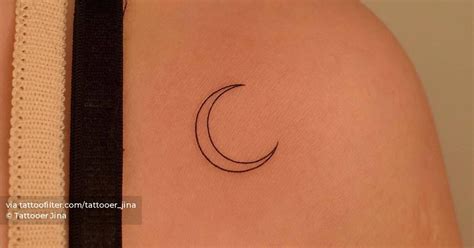 Minimalistic crescent moon tattoo placed on the