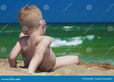 Kleiner Junge Auf Dem Strand. Kind, Das in Sand.Summer.sea.sky Sitzt