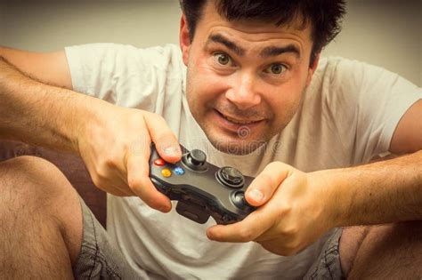 Эмоциональный молодой пристрастившийся человек играя видеоигры Стоковое ...