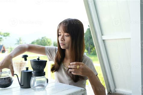 Asian female tourist Grind and brew coffee to drink in the morning