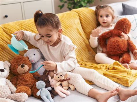 Two Kids Playing with Dolls Sitting on Sofa at Home Stock Image - Image ...