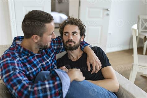 Loving Same Sex Male Gay Couple Lying On Sofa At Home And Relaxing