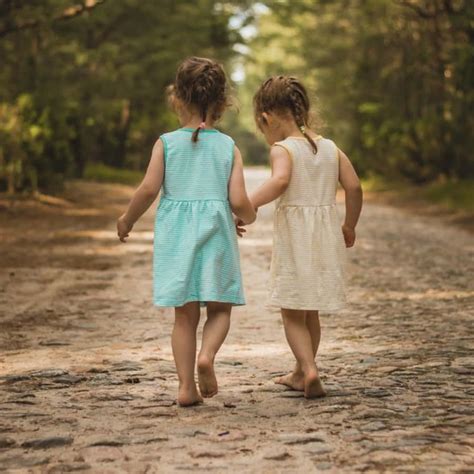 Download Two Little Girls Walking Down A Road In The Forest ...