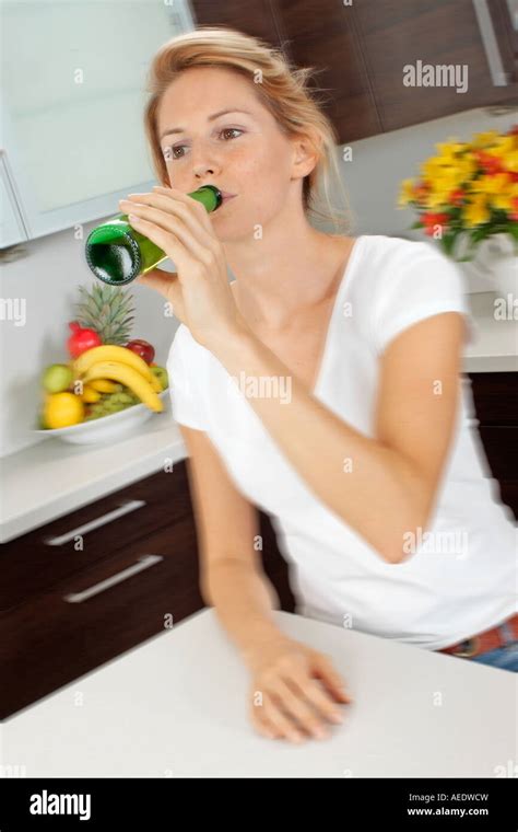 woman  kitchen drinking  bottle  beer stock photo alamy