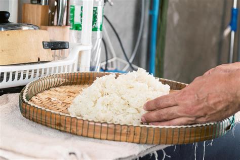 Hands placing steamed white rice on a bamboo tray 2029039 Stock Photo