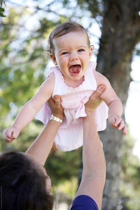 "Mom Holding Very Happy Baby Girl In The Air" by Stocksy Contributor