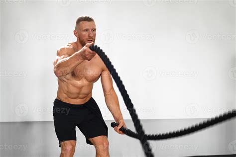 Gym battle rope man stamina training Athlete guy fitness exercising