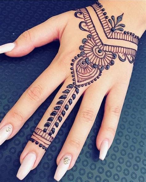 a woman's hand with henna tattoos on it