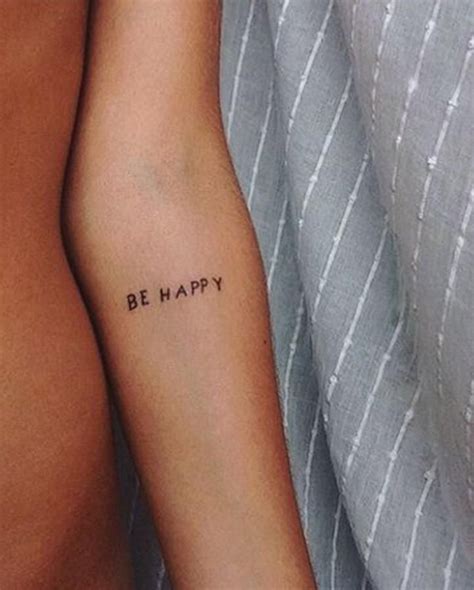 a woman's arm with the words be happy tattooed on her left arm, in ...