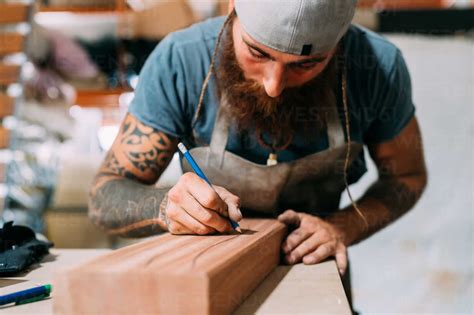 axe maker measuring wood  axe handle  workshop stock photo