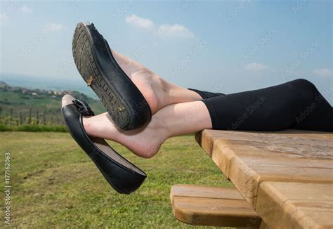 girl dangling flat shoes   wood table stock photo adobe stock