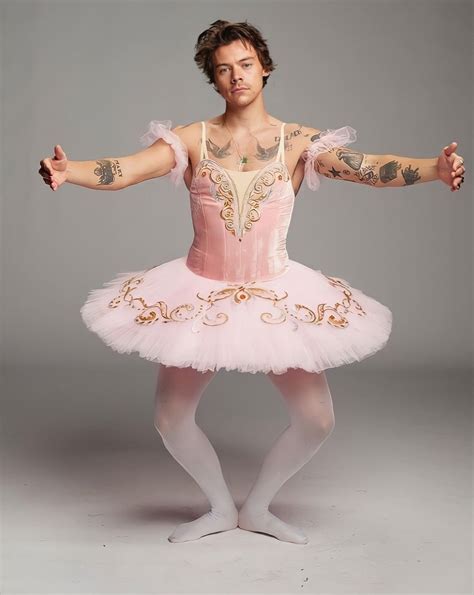 a man in a pink tutu with tattoos on his arm and arms stretched out