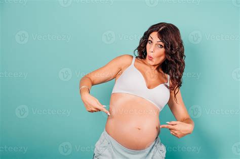 Pregnant amazed woman expecting a child caresses her belly 20621354