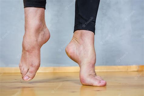Premium Photo | Barefoot female feet in black leggings on a wooden floor