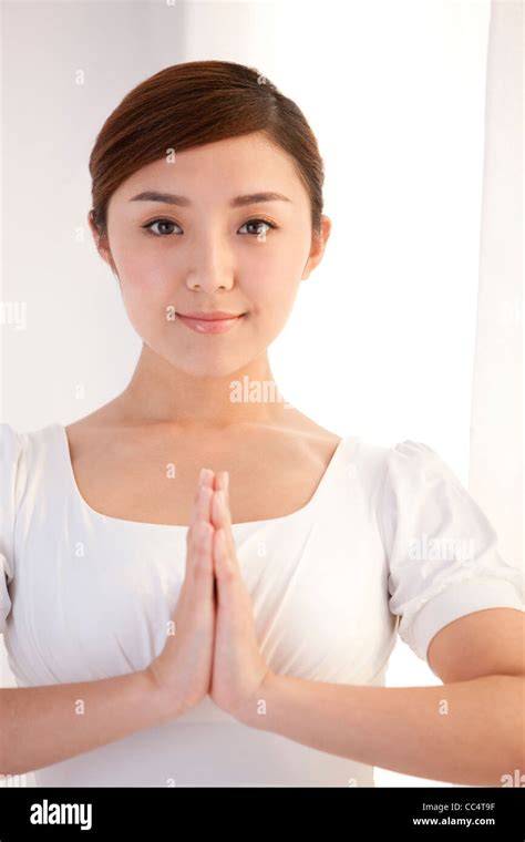 Young woman with hands together Stock Photo - Alamy