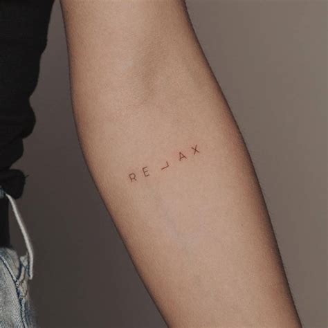 "Relax" lettering tattoo on the inner forearm