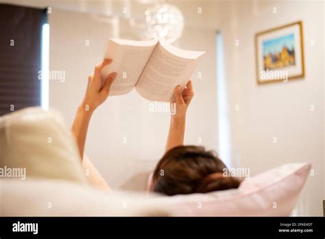 Woman reading a book lying down Stock Photo - Alamy