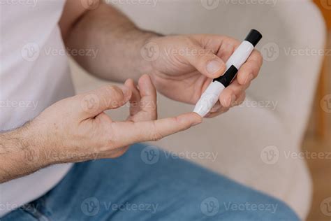 Diabetic senior man on wheelchair checking blood sugar level with