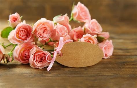 Premium Photo | Fresh roses and card on wooden background