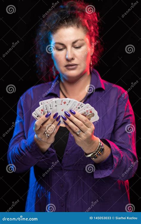 A Woman in Purple Clothes Holds a Deck of Cards and Shows Tricks Stock ...