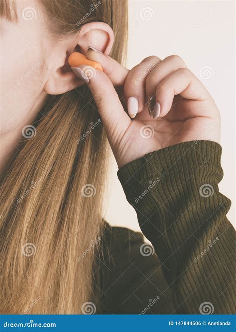 Frau, Die Ohrenst?psel in Ohren Setzt Stockfoto - Bild von