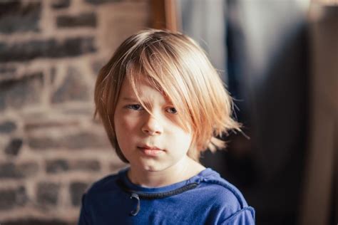 Premium Photo | Young shaggy boy with a displeased facial expression