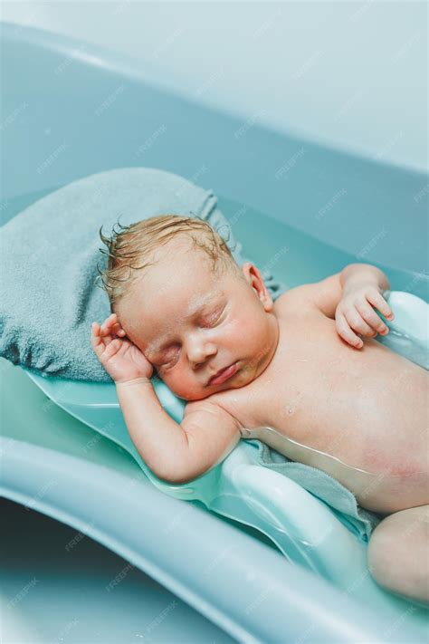Premium Photo | A newborn baby lies on a stand in a bathtub for bathing