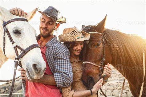contento Pareja teniendo divertido con caballos dentro estable - joven