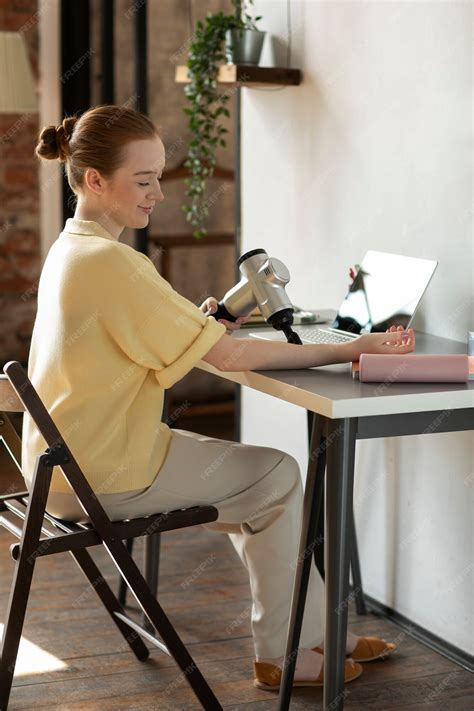 Premium Photo | Woman using massage gun on forearm full shot