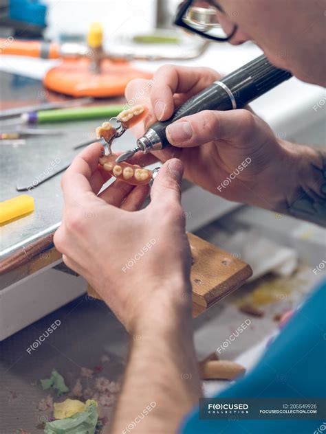 Dental technician polishing teeth — jaw, unrecognizable - Stock Photo