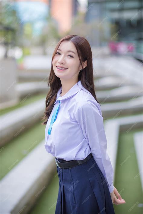 그녀의 치아에 교정기와 교복에 아름 다운 아시아 고등학생 소녀. | 프리미엄 사진