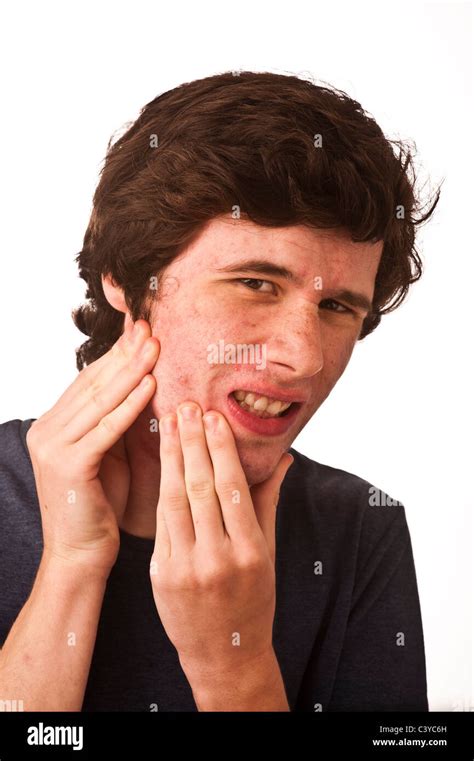 A young adult man with bad complexion, acne, checking his face for ...