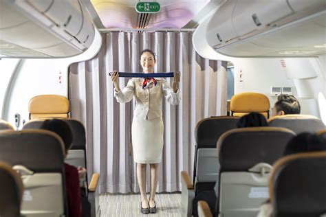 Asian flight attendant is demonstrating safety procedure using seat