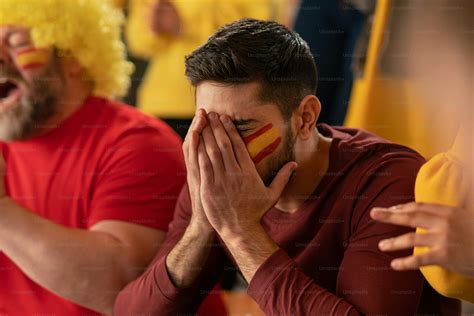 Worried football fans supproting a spanish national team in live soccer