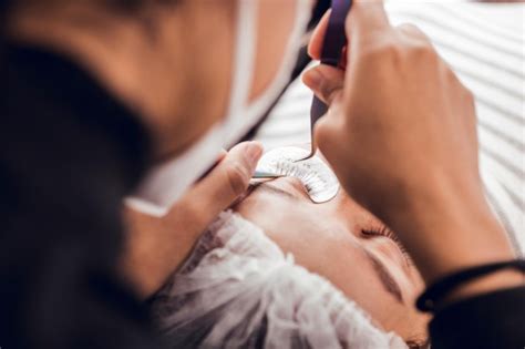Premium Photo | Shallow focus of a female putting false eyelashes on a ...