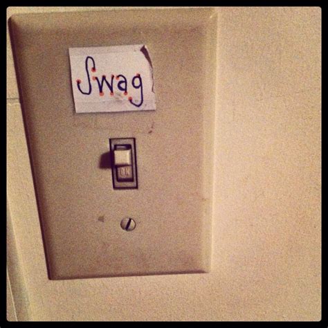 a white wall mounted light switch with a sign that says uwag on it