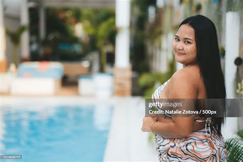 portrait  beautiful curvy young woman sitting  swimming pool high