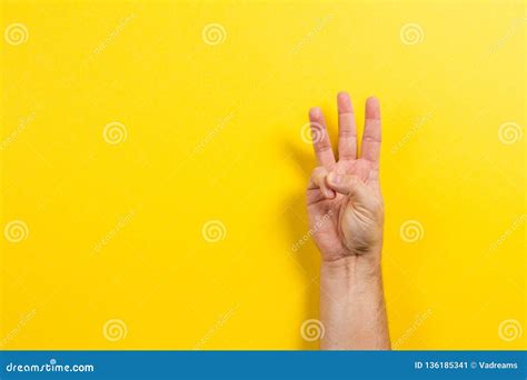 man hand showing  fingers  yellow background number  symbol
