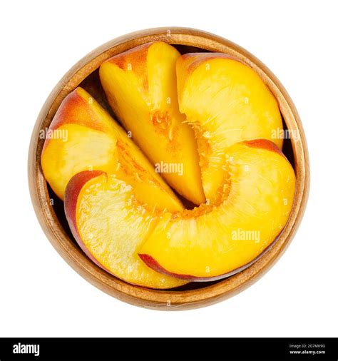 Peach slices in a wooden bowl. Sliced ripe fruit, with a yellow and ...