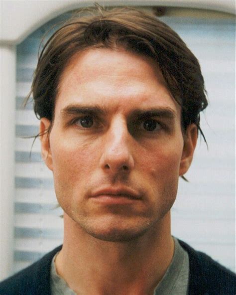 a close up of a person wearing a suit and tie in front of a window
