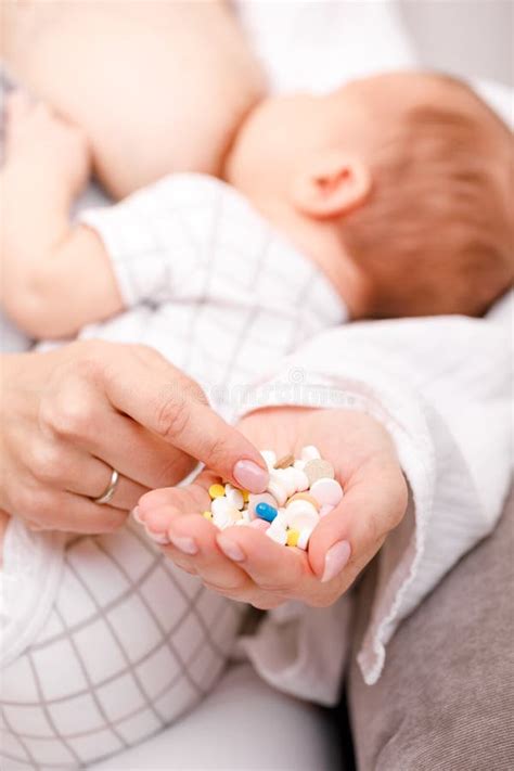 Remedio Para Segurar O Bebe - Mãe a Segurar Um Punhado De Medicamentos Enquanto Amamenta O Bebê Recém ...