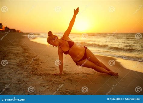 Authentic Woman In Swimsuit Doing Yoga Vasisthasana On The Beach In The ...