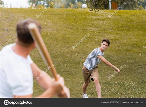 selective focus teenager boy throwing ball  playing baseball