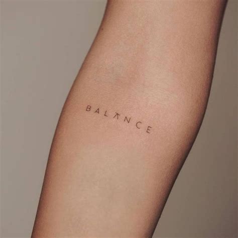 a woman's arm with the word balance tattooed on her left side, in ...
