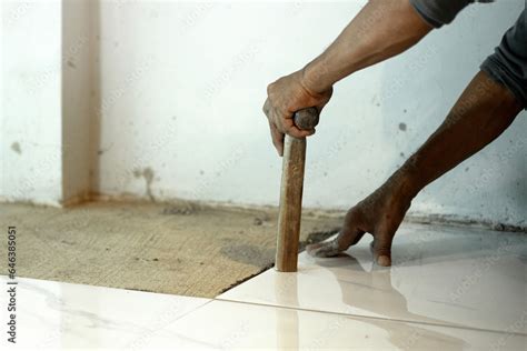 Laying ceramic tiles, close up hands of the worker are laying the ...